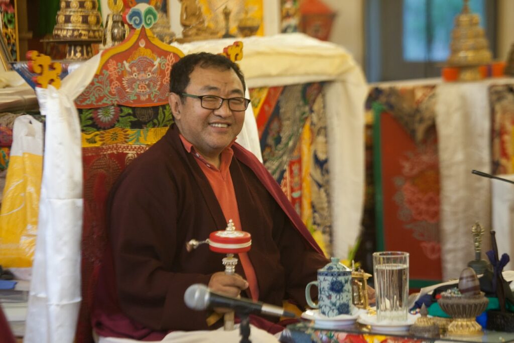 Tromge Jigme Rinpoche with a prayer wheel.
